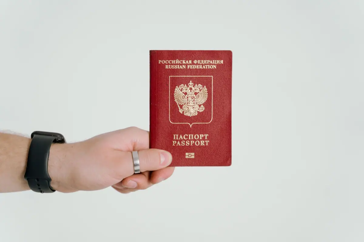 Uma mão segura um passaporte russo
