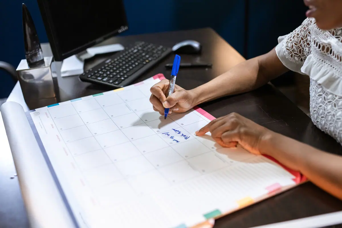 Uma pessoa anota datas em um calendário de mesa
